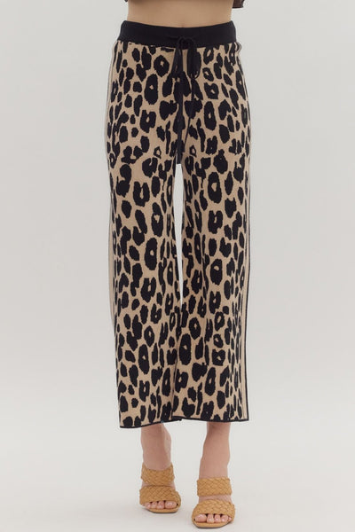 Leopard print pants worn by a person on a white background