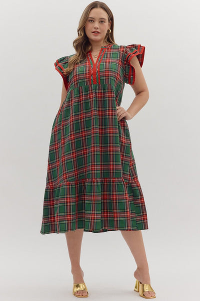 Woman wearing a red and green plaid dress on a white background
