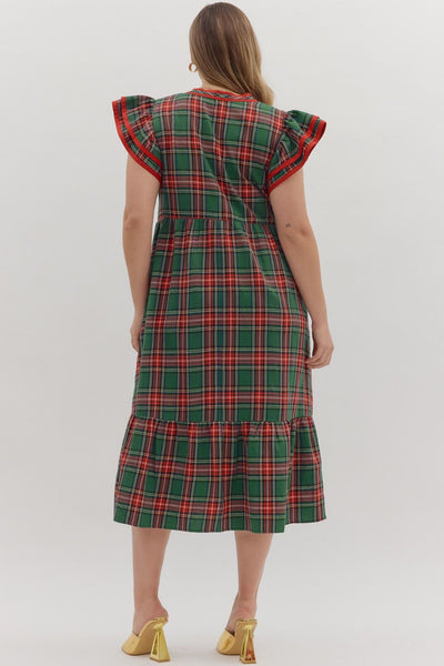 Woman wearing a green plaid dress with ruffled sleeves on a white background