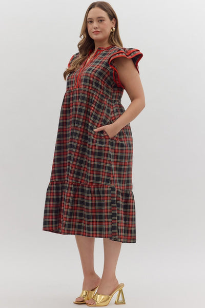 Woman wearing a plaid dress with ruffled sleeves on a white background