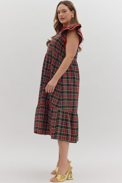 Woman wearing a plaid dress with ruffled sleeves on a white background