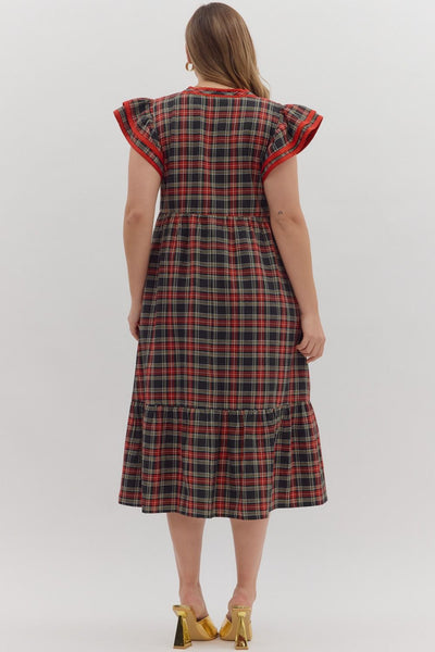 Woman wearing a red and black plaid dress on a white background