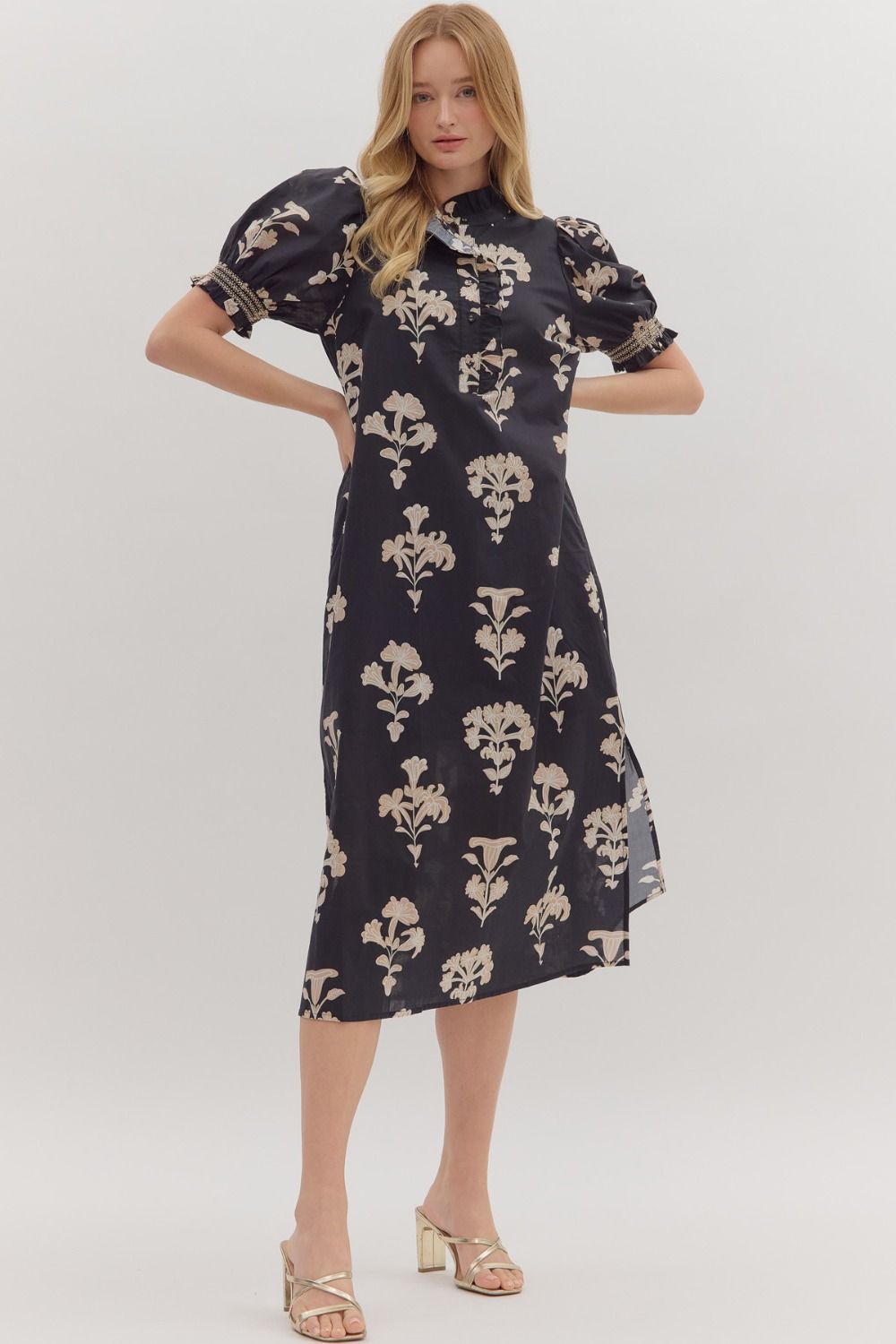 Woman wearing a navy dress with floral pattern on a white background