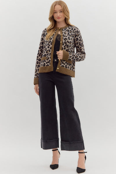 Woman wearing a leopard print cardigan and black pants on a white background