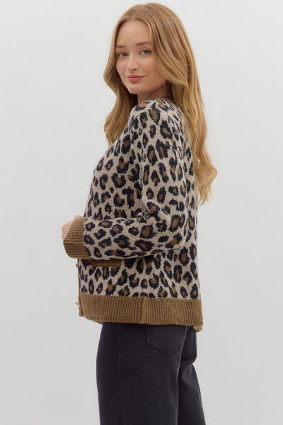 Woman wearing a leopard print sweater with a plain background