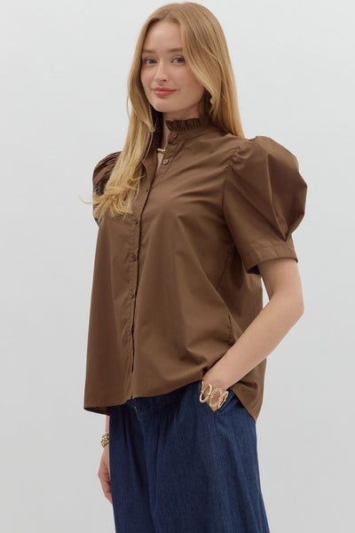 Woman wearing a brown blouse and blue pants on a white background