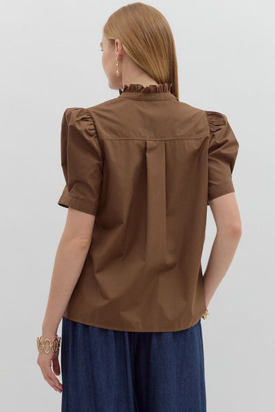 Woman wearing a brown blouse with puff sleeves on a white background