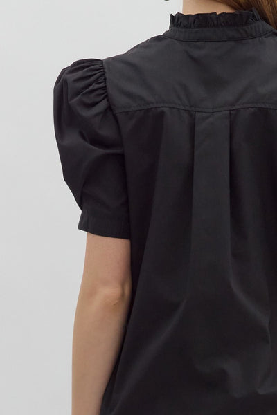 Black blouse with puff sleeves on a plain background