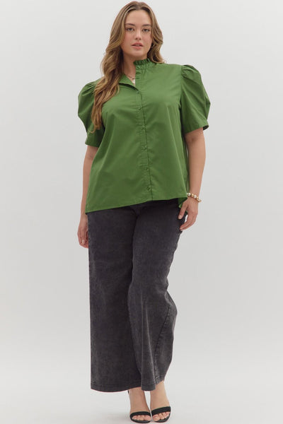 Woman wearing a green blouse and dark pants on a white background