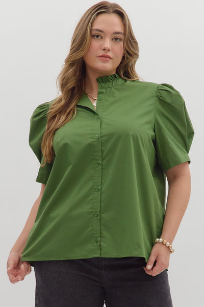 Woman wearing a green blouse with puff sleeves on a plain background