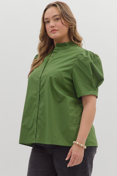 Woman wearing a green blouse with puff sleeves against a white background