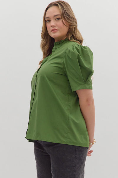Woman wearing a green blouse with puff sleeves against a white background