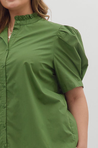 Green shirt worn by a person on a plain background