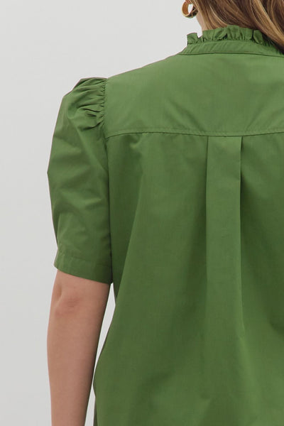 Green shirt worn by a person on a plain background