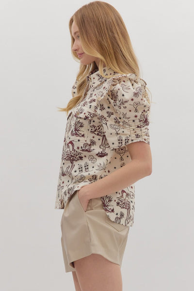 Woman wearing a floral blouse and beige shorts on a white background