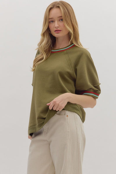 Woman wearing an olive green sweater with a white background