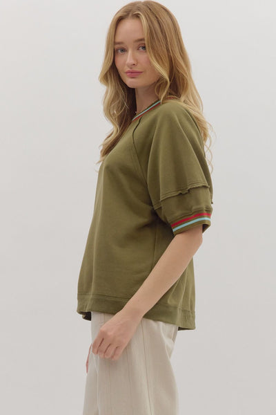 Woman wearing a green oversized shirt with a white background