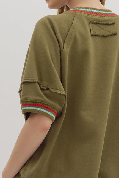 Green oversized shirt with striped cuffs on a plain background