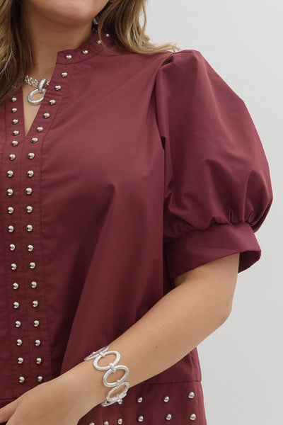 Maroon blouse with silver embellishments worn by a person, with a focus on the upper body.
