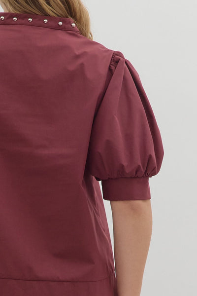 Maroon dress with puffed sleeves on a plain background
