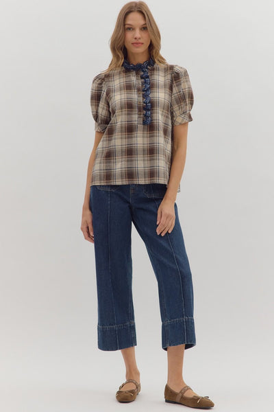 Woman wearing a plaid shirt and blue jeans on a white background