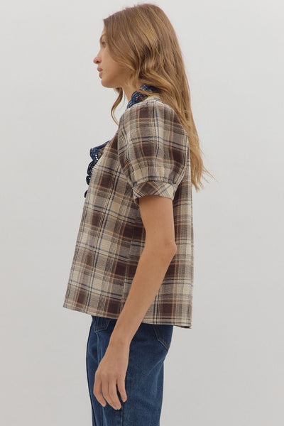Woman wearing a plaid shirt and jeans on a plain background