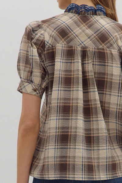 Plaid shirt with puff sleeves worn by a person on a white background