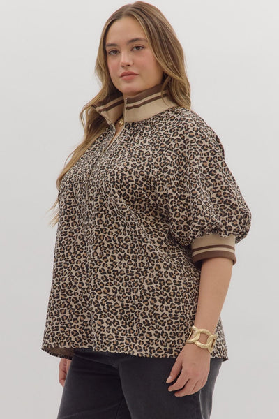 Woman wearing a leopard print blouse with a plain background