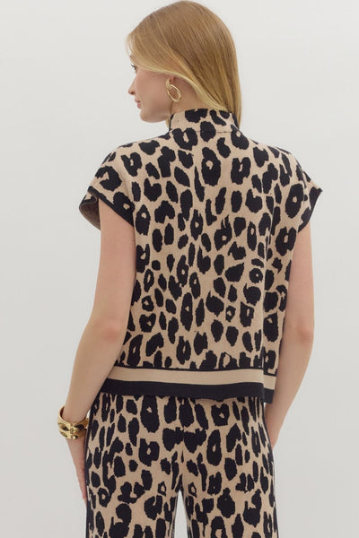 Person wearing a leopard print outfit on a plain background
