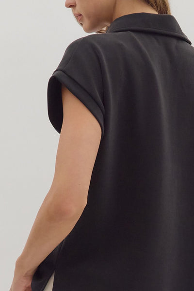 Black sleeveless top worn by a person on a plain background