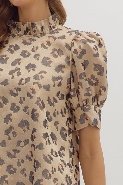 Leopard print blouse with puff sleeves on a plain background