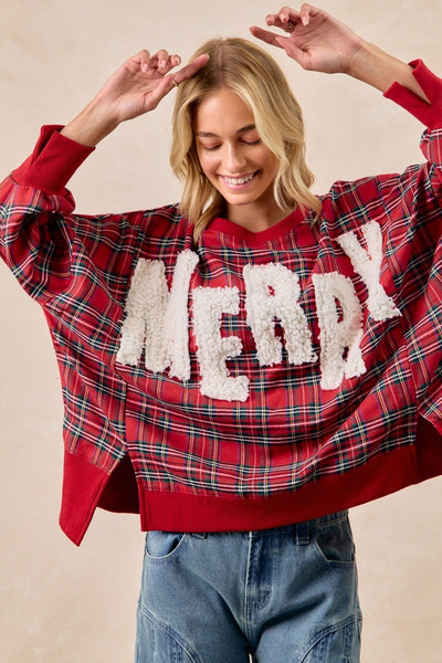 Person wearing a red plaid sweater with 'Merry' text on a beige background