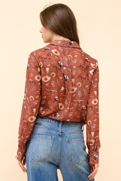 Person wearing a patterned blouse and blue jeans on a beige background