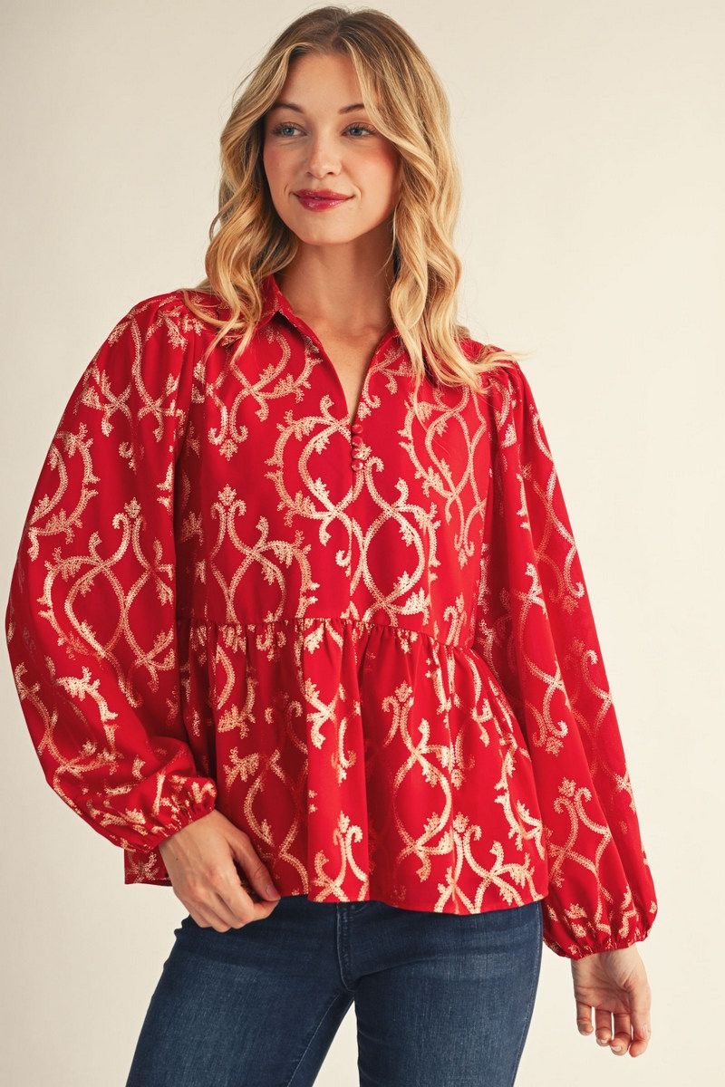 model wearing red and gold puff sleeve blouse with jeans in front of a beige background