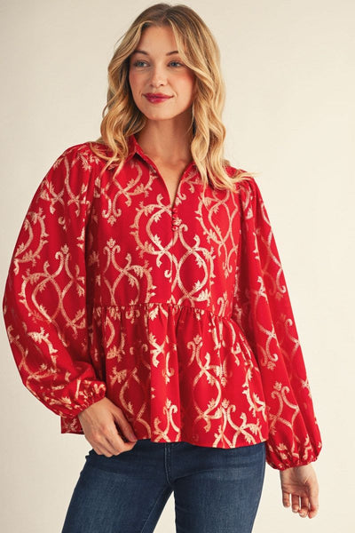 model wearing red and gold puff sleeve blouse with jeans in front of a beige background
