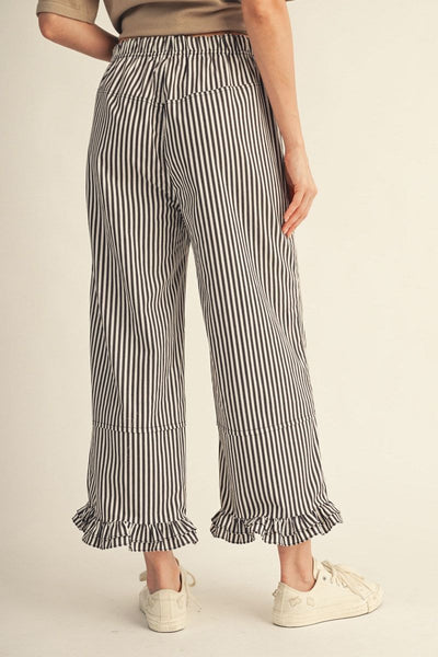 Striped pants worn by a person on a beige background