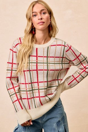 Woman wearing a plaid sweater with red and green lines on a beige background