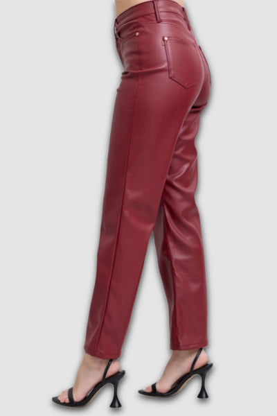 Red leather pants worn by a person on a white background