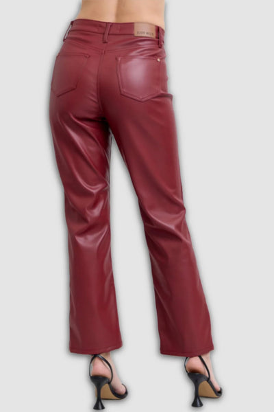 Maroon leather pants worn by a person on a light gray background
