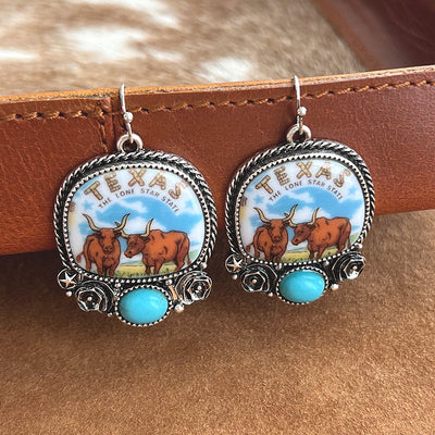 Texas longhorn earrings on tan background