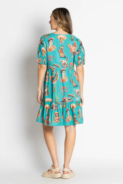 back view of a model wearing a Mexican themed dress with off white background